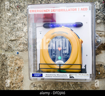 Montage mural au défibrillateur d'urgence dans une rue Mousehole, Cornwall, UK Banque D'Images