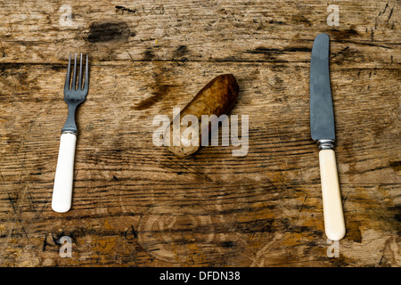 Saucisses sur table en bois avec fourchette et couteau Banque D'Images