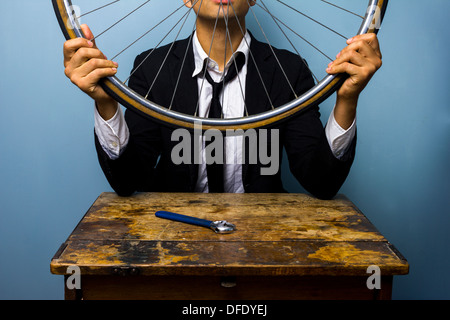 Jeune homme a fixé sa roue de bicyclette Banque D'Images