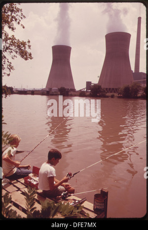 LES GARÇONS PÊCHENT DANS LA RIVIÈRE KANAHHA À POCA. SUR L'AUTRE RIVE, LA VAPEUR S'ÉLÈVE DES TOURS DE REFROIDISSEMENT D'EAU DU JOHN... 551162 Banque D'Images