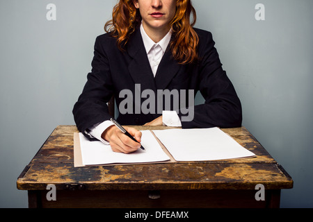 Young businesswoman est assis à un vieux bureau et écriture Banque D'Images