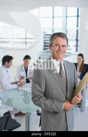 Portrait of smiling businessman in réunion avec les médecins Banque D'Images