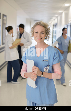 Portrait of smiling nurse in hospital corridor Banque D'Images