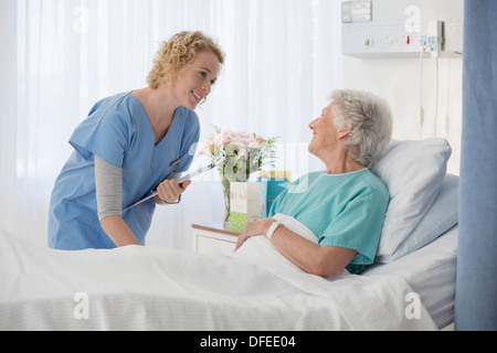 Infirmière et vieillissement patient talking in hospital room Banque D'Images