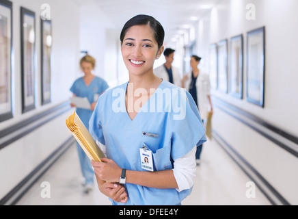 Portrait of smiling nurse in hospital corridor Banque D'Images