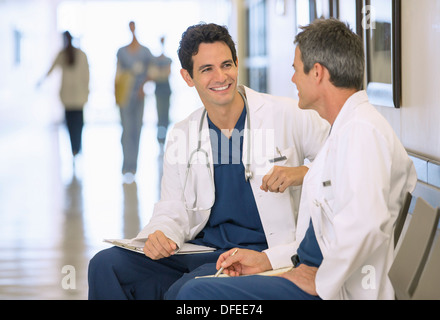 Doctors talking in hospital corridor Banque D'Images