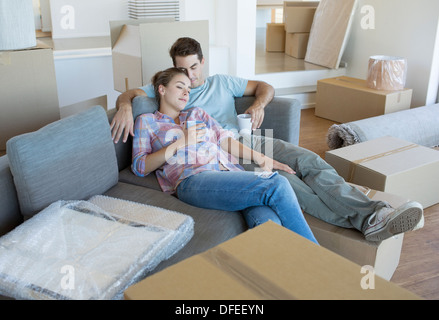 Couple relaxing on sofa in new house Banque D'Images