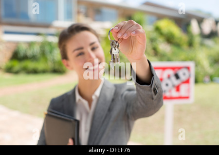 Portrait de realtor holding clés de maison en face de la maison Banque D'Images