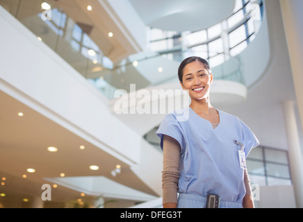 Portrait of smiling nurse in hospital atrium Banque D'Images