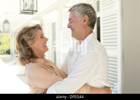 Senior couple hugging on patio Banque D'Images