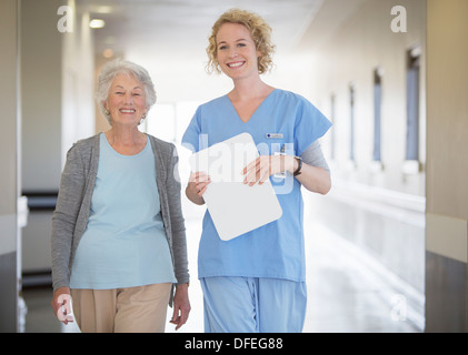 Portrait of smiling nurse and senior patient in hospital corridor Banque D'Images
