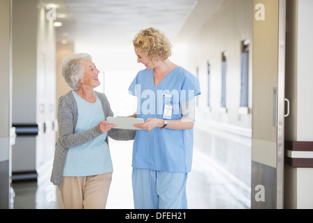 Infirmière et senior patient talking in hospital corridor Banque D'Images