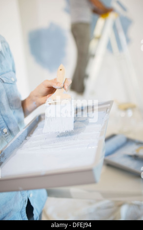 Woman holding bac à peinture avec peinture bleu Banque D'Images