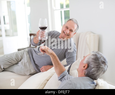 Senior men toasting wine glasses Banque D'Images