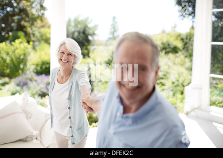 Senior couple holding hands on patio Banque D'Images