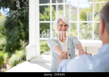 Senior couple dancing on patio Banque D'Images