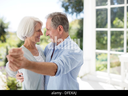 Senior couple dancing on patio Banque D'Images