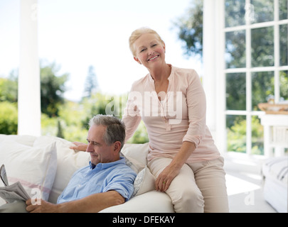 Senior couple relaxing on sofa on porch Banque D'Images