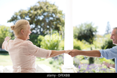 Senior couple dancing on patio Banque D'Images