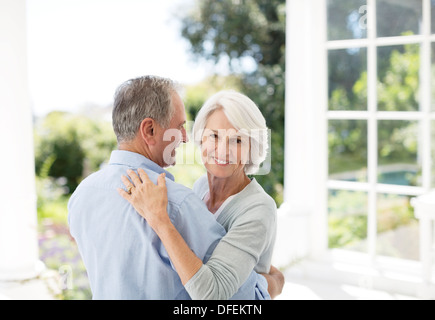 Senior couple dancing on patio Banque D'Images