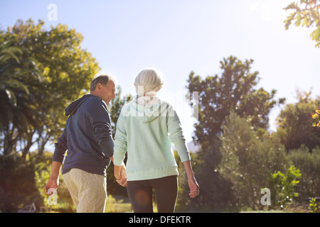 Senior couple holding hands and walking in park Banque D'Images