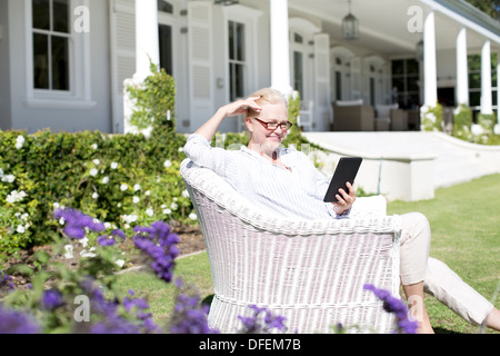 Senior woman using digital tablet in garden Banque D'Images