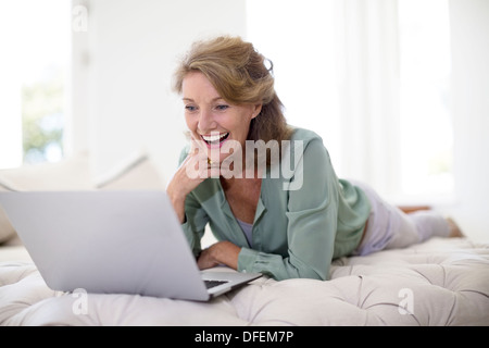 Senior woman using laptop in living room Banque D'Images