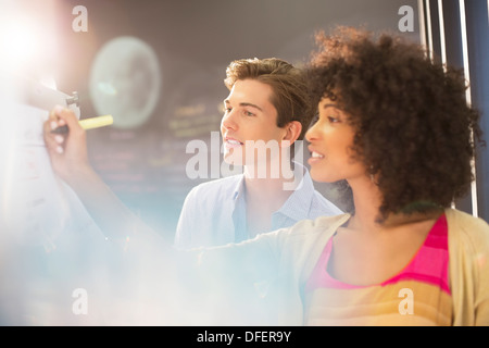 Les gens d'affaires l'écriture sur tableau blanc bureau Banque D'Images