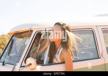 Woman leaning head out fenêtre camping-car Banque D'Images