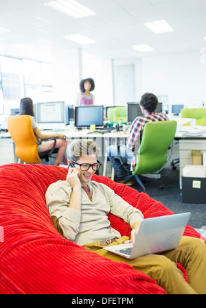 Businessman working in fauteuil poire in office Banque D'Images