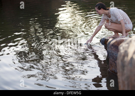 Femme trempant dans le lac à la main Banque D'Images