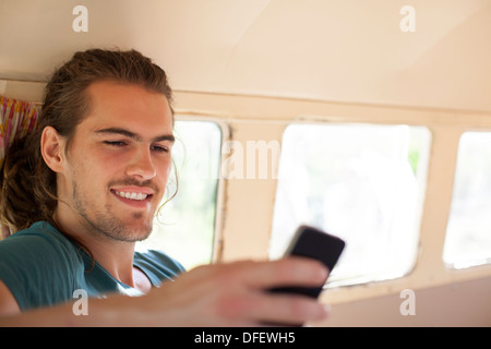 Man using cell phone in camper van Banque D'Images