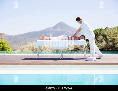 Woman receiving massage at poolside Banque D'Images