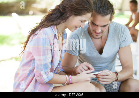 Couple listening to mp3 player outdoors Banque D'Images