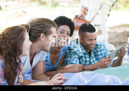 Des amis à l'aide de digital tablet on blanket Banque D'Images