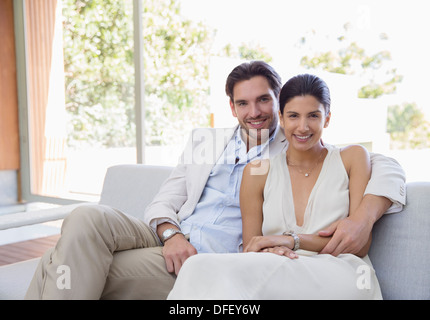 Portrait of smiling couple on sofa Banque D'Images