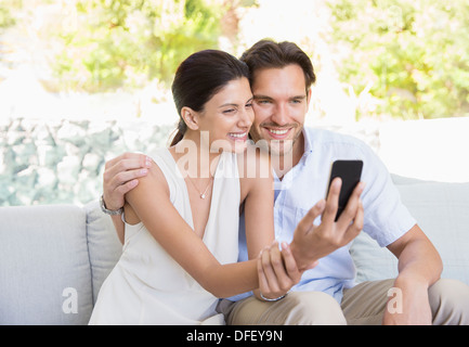 Couple taking self-portrait with camera phone Banque D'Images