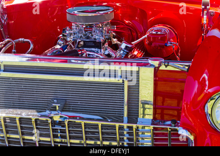 Vue frontale d'une Chevrolet 1955 avec capot chromé montrant le moteur. Banque D'Images