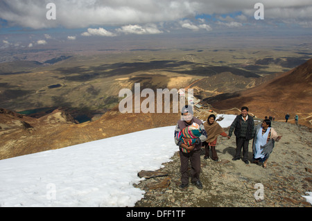 Famille bolivienne portant leur enfant nouveau-né à la 5421 m (17 785 ft) Sommet du Chacaltaya comme une tradition locale, montrant les restes de la le glacier de Chacaltaya, près de La Paz, Bolivie Banque D'Images