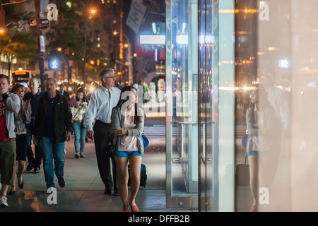 Les touristes et les acheteurs passer le magasin Guess sur la Cinquième Avenue à Manhattan, à New York Banque D'Images