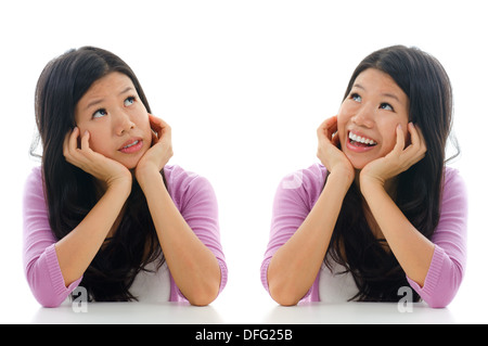 Triste et heureux face expression d'Asian Woman, hands holding face sitting isolé sur fond blanc. Banque D'Images