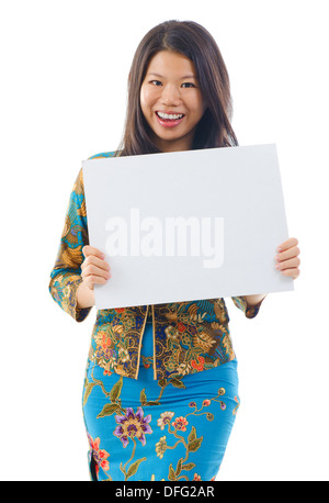 Asian Woman in Kebaya holding a white blank card, kebaya généralement porté par les femmes en Indonésie, Malaisie, Brunei, Singapour, la Birmanie, Thaïlande du sud. Banque D'Images