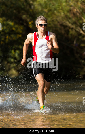 Jogger qui traverse un ruisseau, Winterbach, Bade-Wurtemberg, Allemagne Banque D'Images