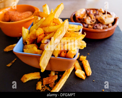 Des tapas espagnoles. Frites, croquettes et calamars tapas dans la plaque d'ardoise Banque D'Images