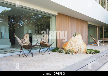 Chaises et rocher sur patio of modern house Banque D'Images