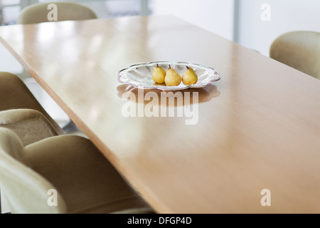 Les poires dans un plat en verre sur une table à manger Banque D'Images