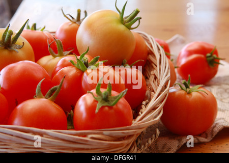 Les tomates dans un panier et en vrac à côté du panier Banque D'Images