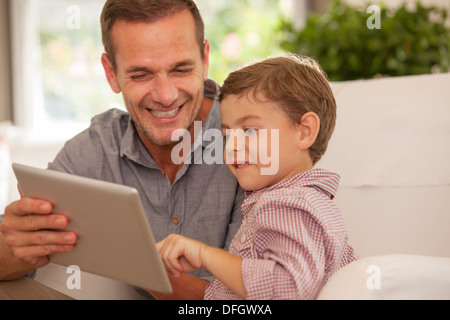 Père et fils using digital tablet Banque D'Images