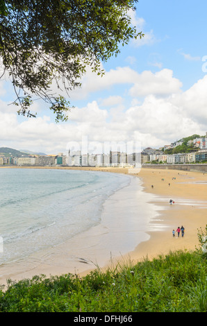 Les marcheurs de la plage au printemps sur la Playa de la Concha, San Sebastian, Espagne San Sebastian, Espagne Banque D'Images