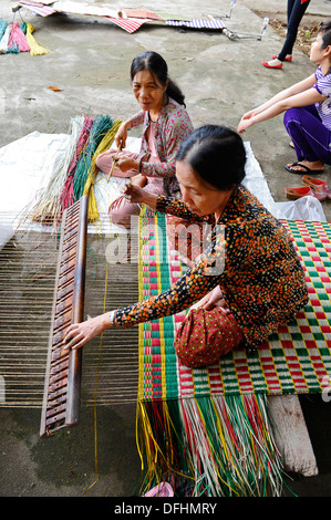 Personnes âgées faisant main vietnamiens reed colorés de tapis. Banque D'Images